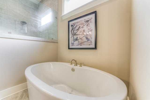 bathroom with tile patterned floors and a tub