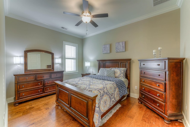 bedroom with light wood-type flooring, ceiling fan, and crown molding