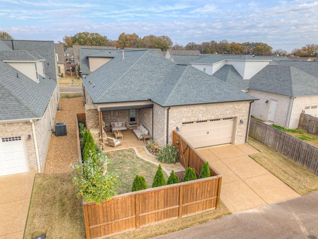 view of front of home featuring cooling unit, a garage, and a patio area