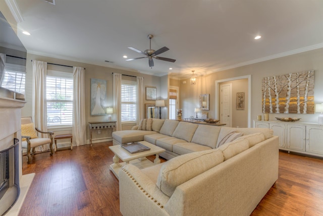 living room with dark hardwood / wood-style flooring, ceiling fan, and crown molding