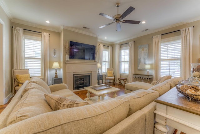 living room featuring ceiling fan, ornamental molding, a healthy amount of sunlight, and hardwood / wood-style flooring