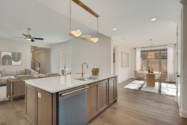 kitchen with dishwasher, pendant lighting, a center island with sink, and sink