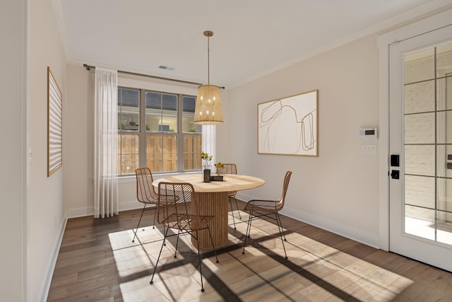 dining space featuring crown molding and hardwood / wood-style floors