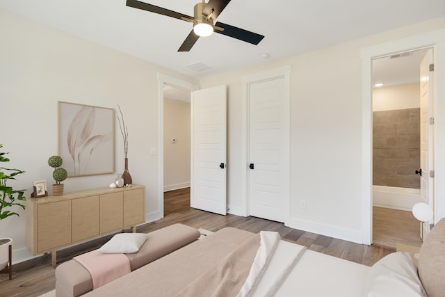 bedroom with ceiling fan, dark hardwood / wood-style flooring, and ensuite bath