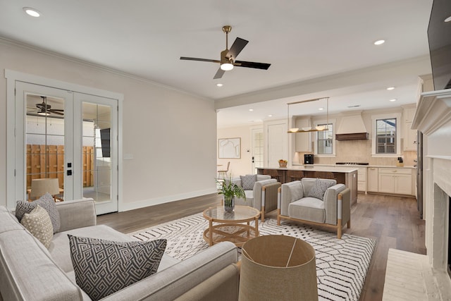 living room featuring dark hardwood / wood-style floors, ceiling fan, ornamental molding, and french doors