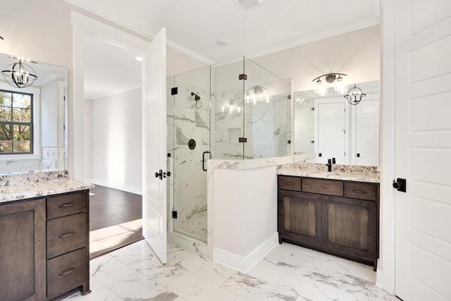 bathroom featuring vanity, an inviting chandelier, a shower with door, and crown molding