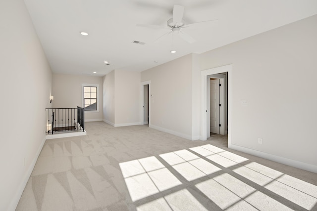 empty room with ceiling fan and light colored carpet