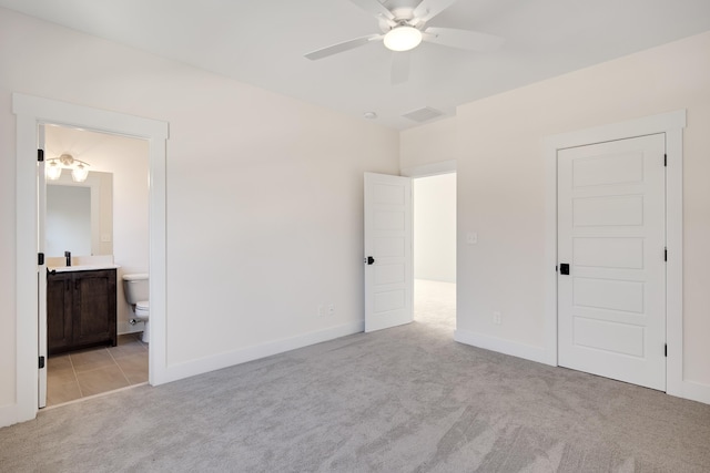 unfurnished bedroom with connected bathroom, light colored carpet, ceiling fan, and sink