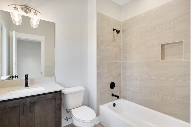 full bathroom with vanity, tiled shower / bath combo, and toilet