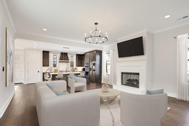 living room with crown molding, dark hardwood / wood-style flooring, and a notable chandelier