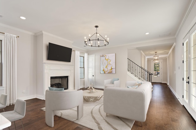 living room featuring a chandelier, ornamental molding, and dark wood-type flooring