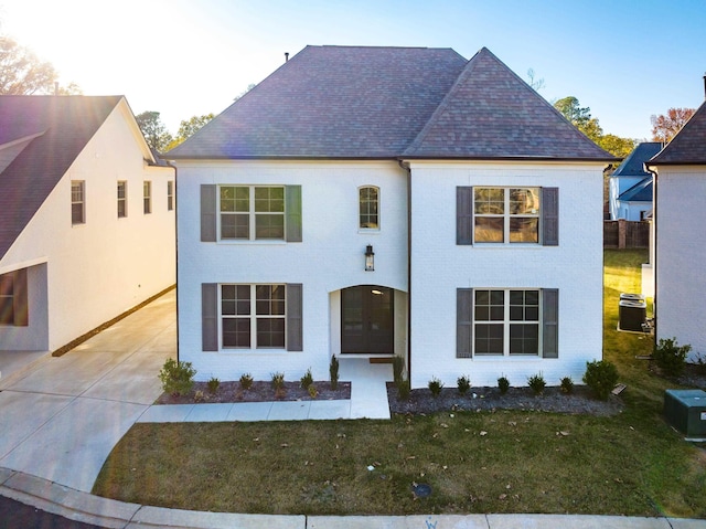 view of front of property with cooling unit and a front yard