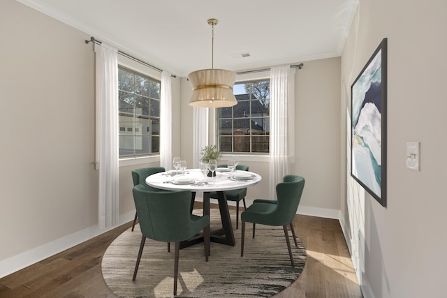 dining area with crown molding and dark hardwood / wood-style floors