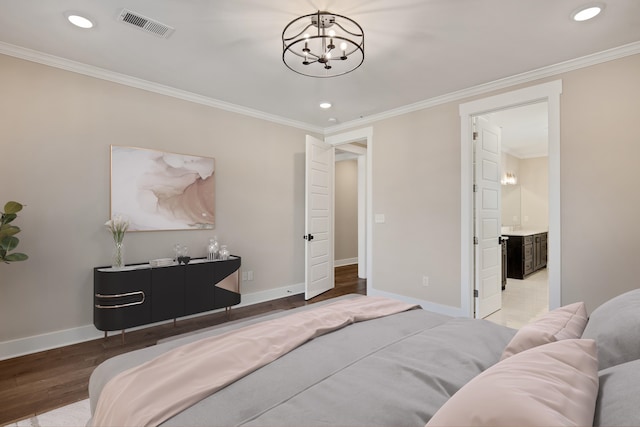 bedroom featuring ensuite bathroom, ornamental molding, a chandelier, and hardwood / wood-style flooring