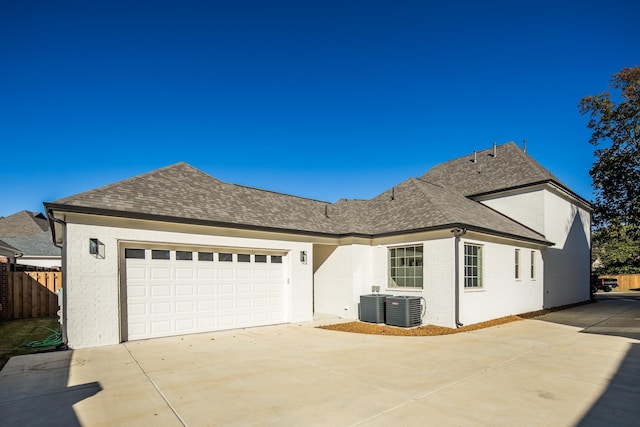 exterior space with a garage and central AC