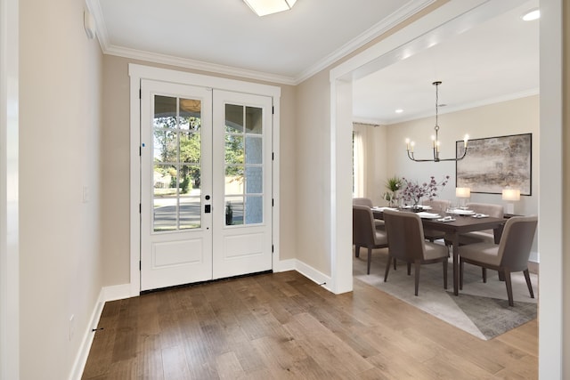 entryway with hardwood / wood-style flooring, ornamental molding, and french doors