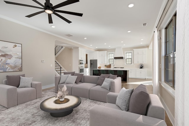 living room featuring crown molding and ceiling fan