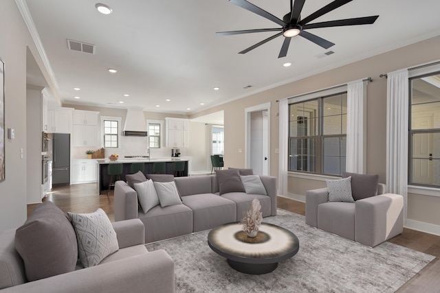 living room featuring dark hardwood / wood-style floors, ceiling fan, and ornamental molding