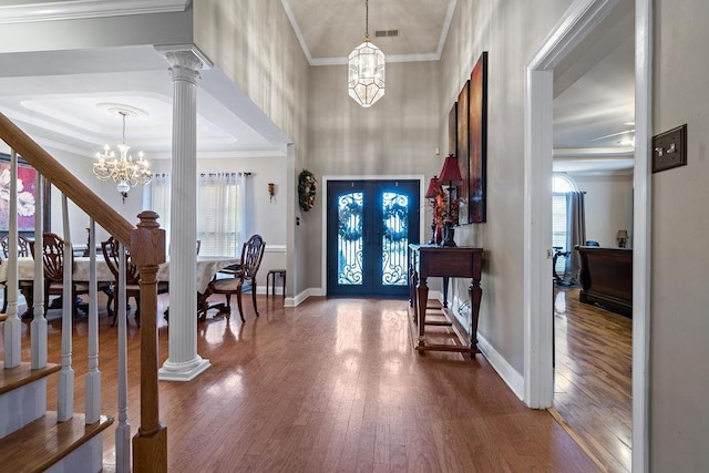 foyer featuring crown molding, hardwood / wood-style flooring, and ornate columns