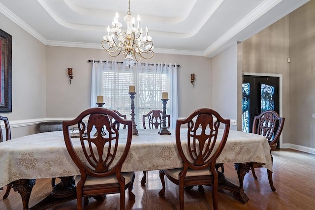 dining space featuring an inviting chandelier, a tray ceiling, and hardwood / wood-style floors