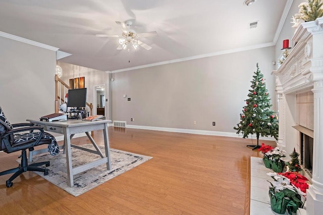 home office with crown molding, ceiling fan, and light wood-type flooring