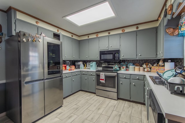 kitchen featuring backsplash, gray cabinetry, sink, and appliances with stainless steel finishes