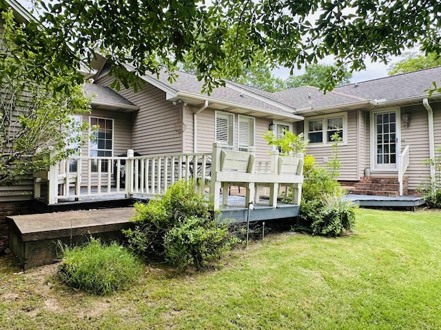 rear view of property with a wooden deck and a yard