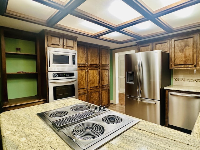 kitchen featuring decorative backsplash, light stone countertops, appliances with stainless steel finishes, and coffered ceiling