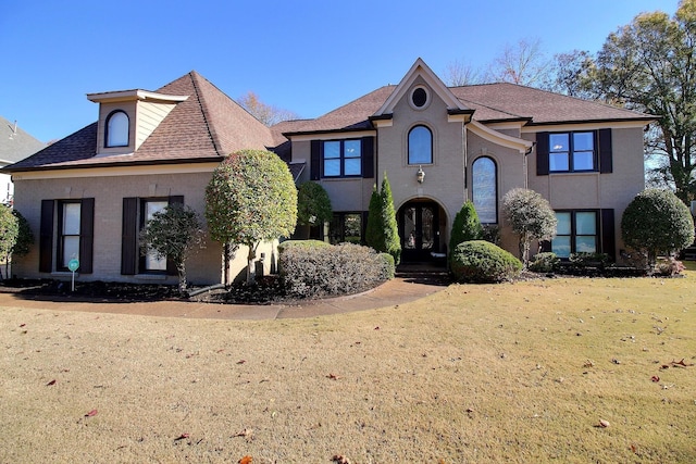 french country home featuring french doors and a front lawn