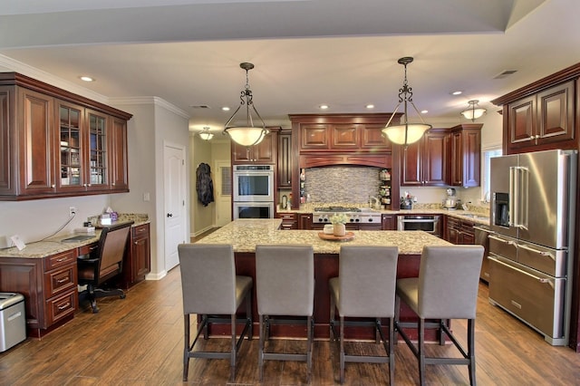 kitchen featuring a center island, dark wood-type flooring, decorative light fixtures, and appliances with stainless steel finishes