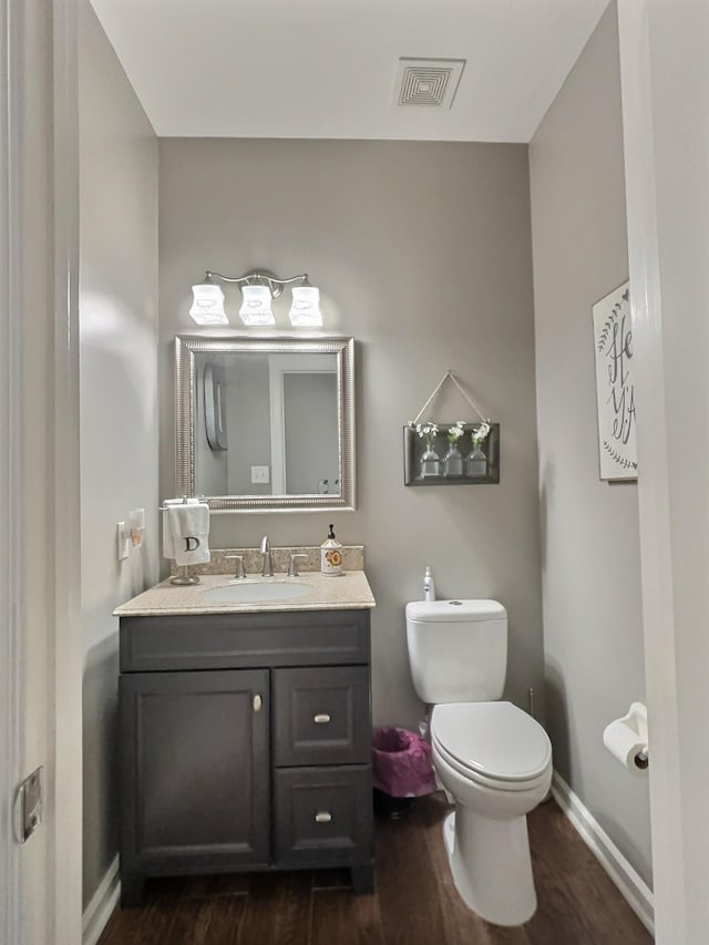 bathroom with hardwood / wood-style flooring, vanity, and toilet