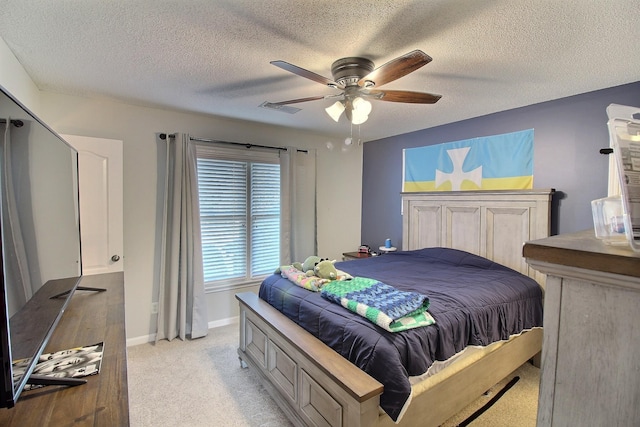 carpeted bedroom featuring a textured ceiling and ceiling fan