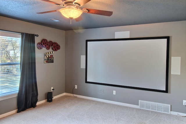 cinema with light carpet, a textured ceiling, and ceiling fan