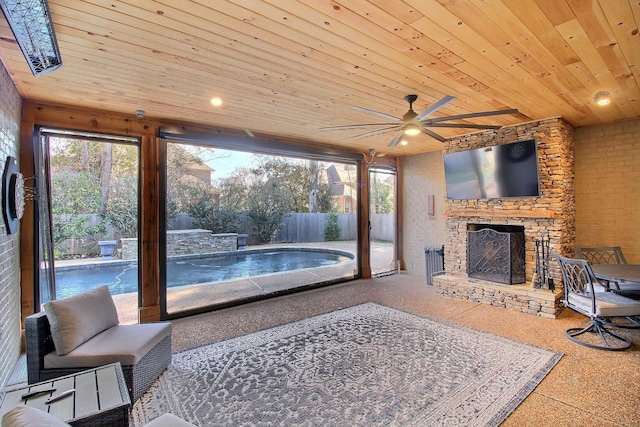 living room featuring a stone fireplace, ceiling fan, and wood ceiling