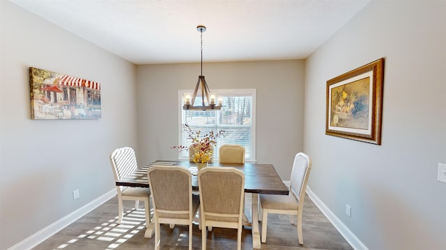 dining space with dark hardwood / wood-style floors and a chandelier