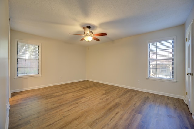 spare room featuring ceiling fan, plenty of natural light, a textured ceiling, and hardwood / wood-style flooring