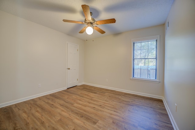 spare room featuring a textured ceiling, light wood-type flooring, and ceiling fan