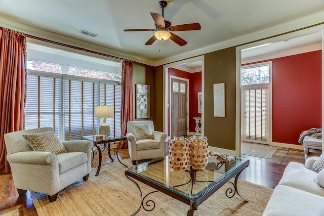 living room with ceiling fan, wood-type flooring, and ornamental molding