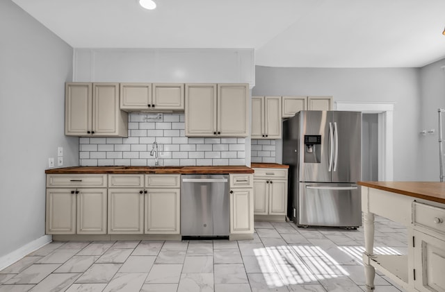 kitchen featuring butcher block counters, sink, cream cabinets, and appliances with stainless steel finishes