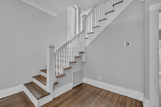 stairs with crown molding and hardwood / wood-style floors