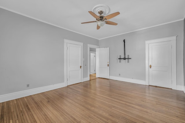 empty room with ceiling fan, light hardwood / wood-style floors, and crown molding