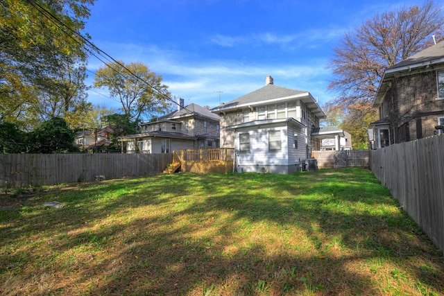 rear view of house featuring a deck and a lawn