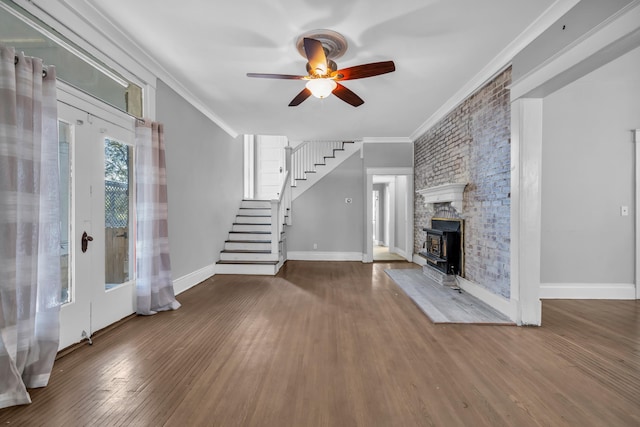 unfurnished living room featuring hardwood / wood-style flooring, ceiling fan, a wood stove, and crown molding