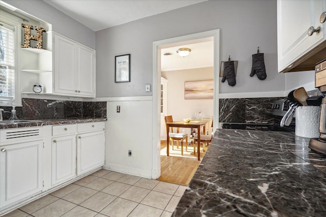 kitchen featuring light tile patterned flooring, white cabinetry, and sink