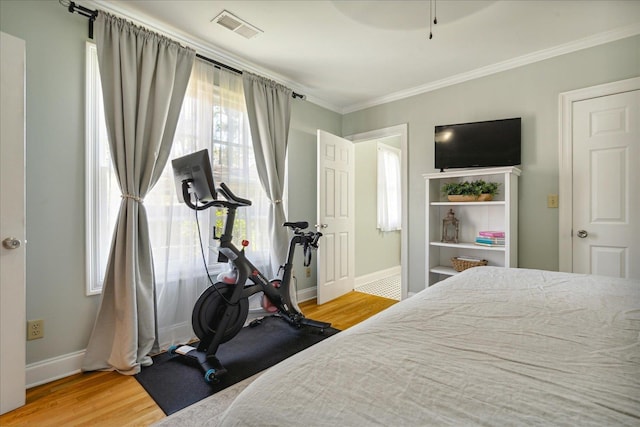 bedroom featuring hardwood / wood-style floors, ceiling fan, and crown molding