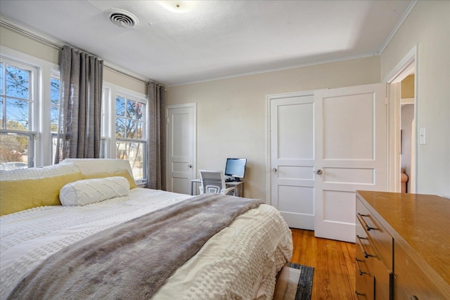 bedroom with light hardwood / wood-style floors and crown molding