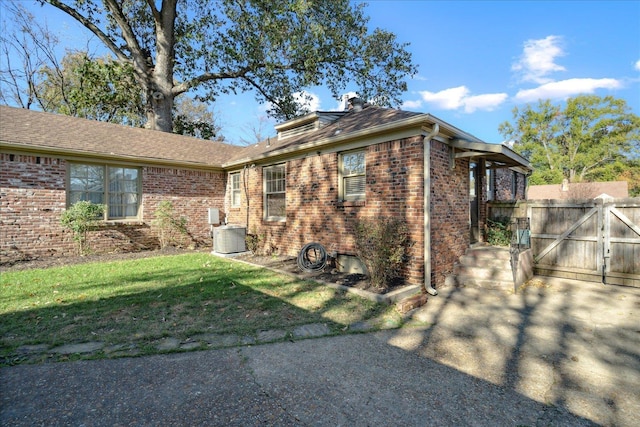 exterior space featuring a front yard and central AC