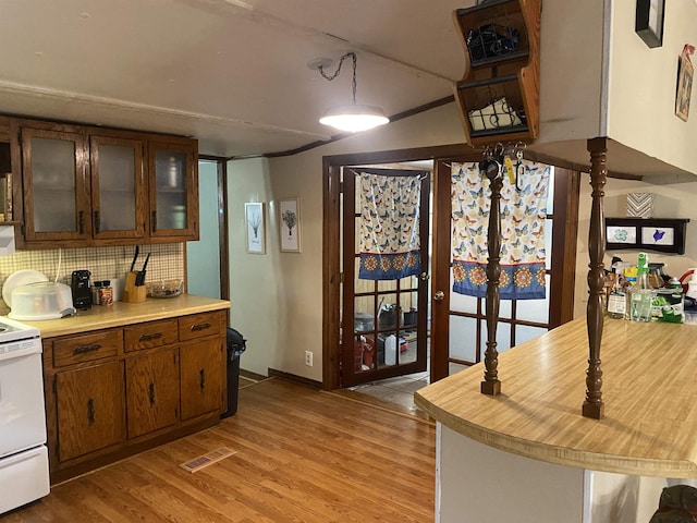 kitchen featuring tasteful backsplash, light hardwood / wood-style floors, and white stove