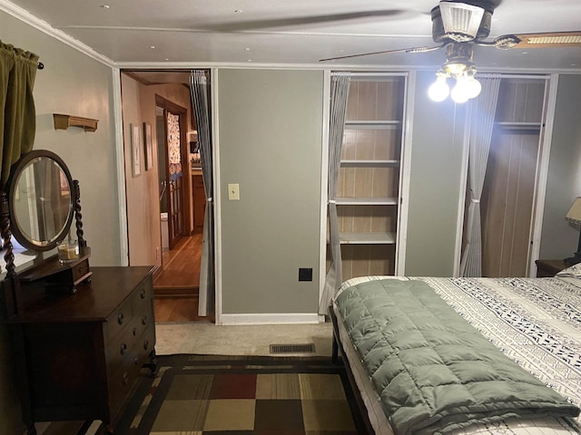 carpeted bedroom with ceiling fan and ornamental molding