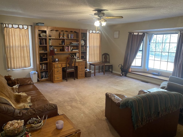 living room with light carpet, ceiling fan, and a textured ceiling